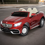 A red kids Mercedes Maybach is controlled by the remote control and driving down the street.
